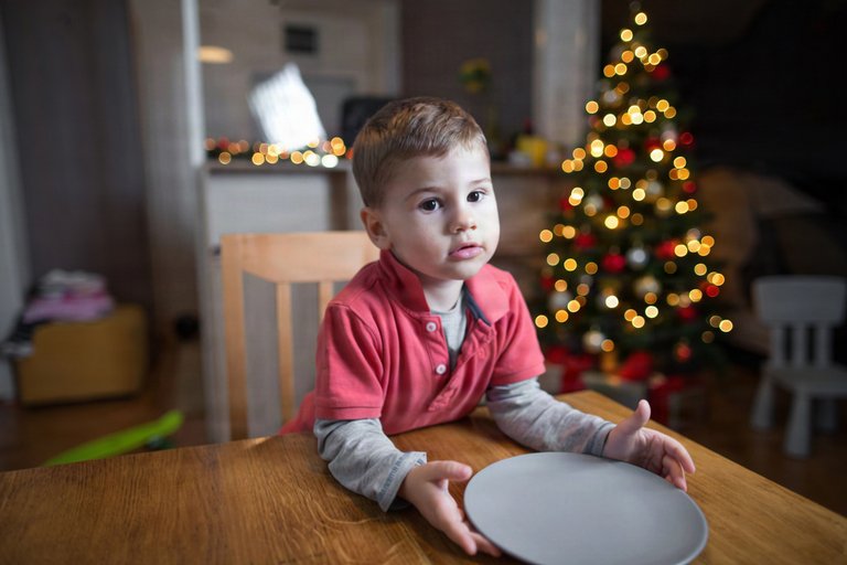 Little boy with an empty plate at Christmas time